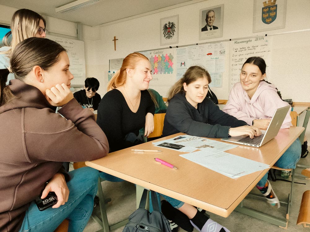Lehrlinge sitzen an einem Tisch und arbeiten an einem Computer