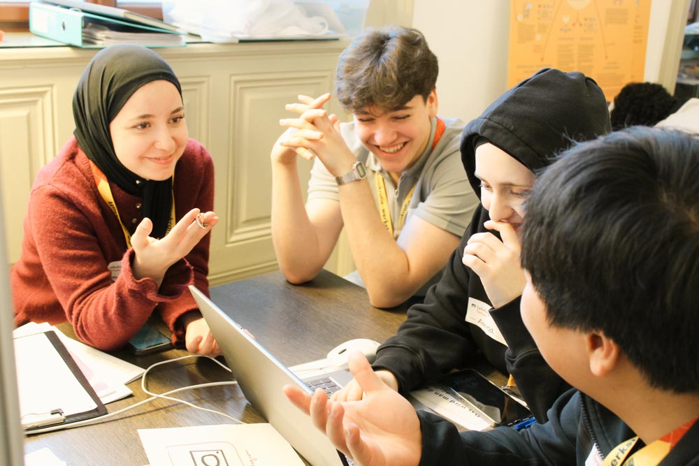 Lehrlinge sitzen am Tisch und diskutieren