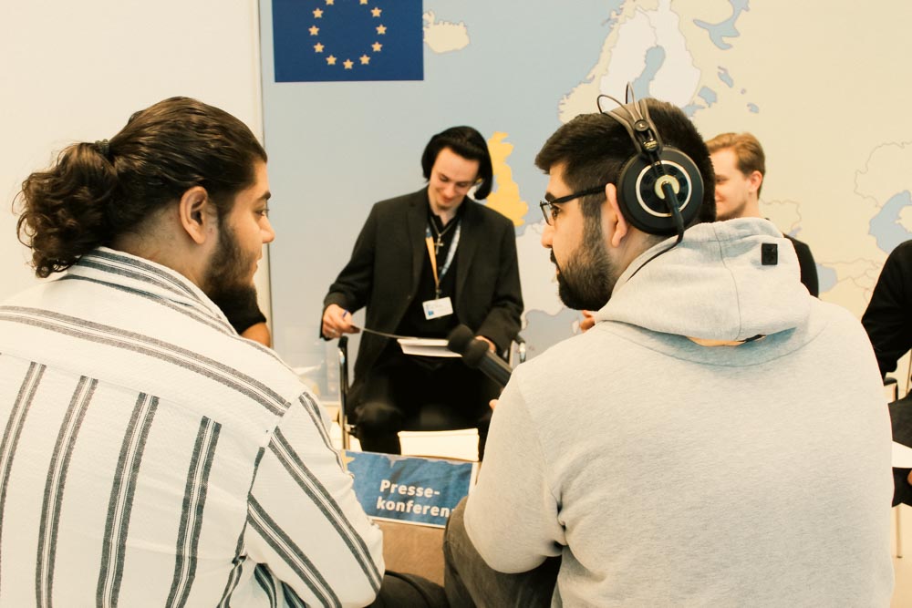 Lehrlinge spielen eine Pressekonferenz nach
