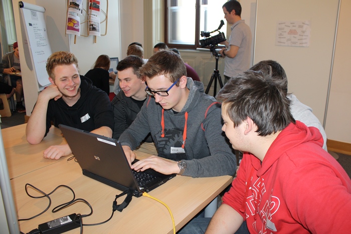 Lehrlinge beim gemeinsamen Verfassen eines Artikels am Laptop