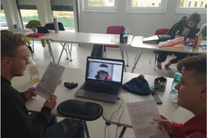 Zwei Lehrlinge sitzen an einem Tisch und arbeiten am Laptop